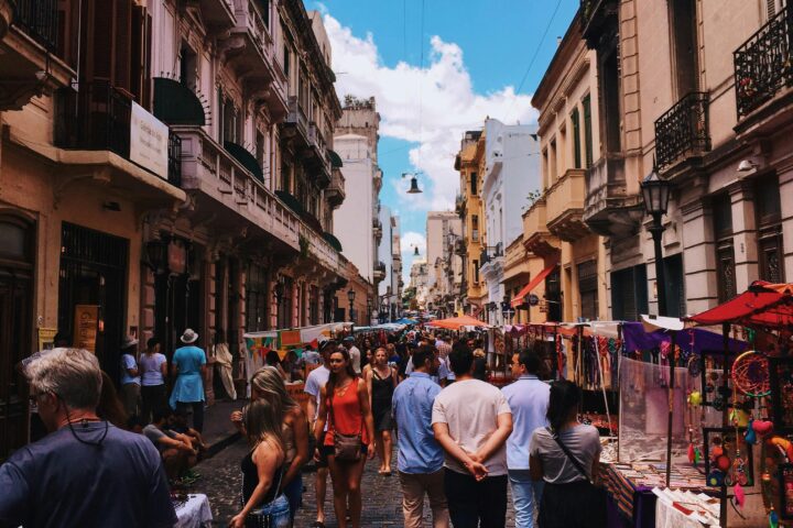 Bustling San Nicolas street market in Buenos Aires with stalls and crowds under a clear sky.