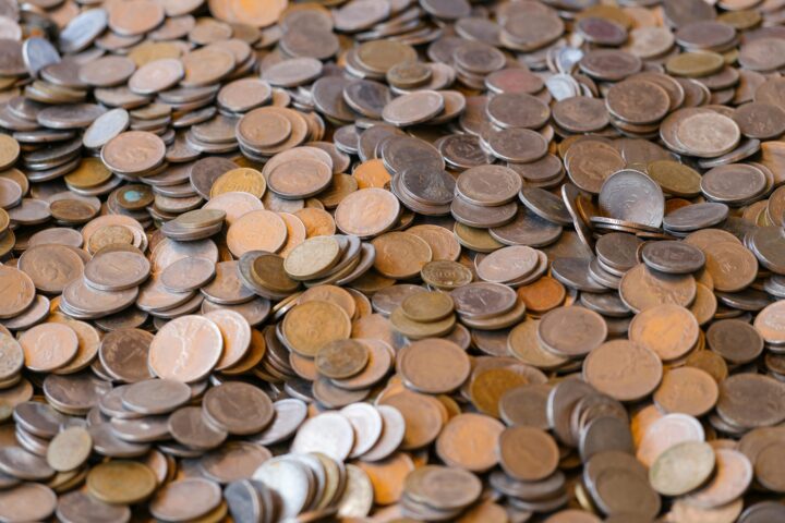 A large pile of mixed coins representing wealth and financial concepts.