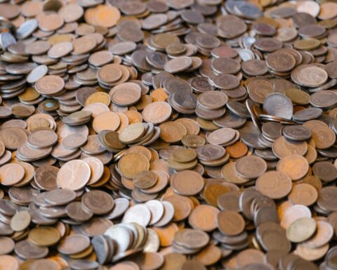 A large pile of mixed coins representing wealth and financial concepts.
