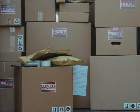 A variety of cardboard boxes labeled 'fragile' stacked in a vehicle for shipping or storage.